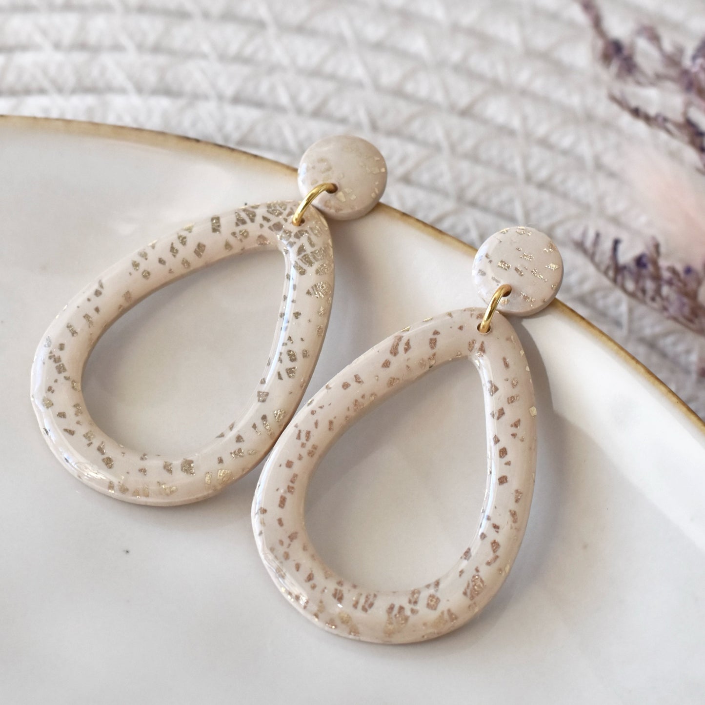 Druppelvorm oorbellen beige met goud vlokjes