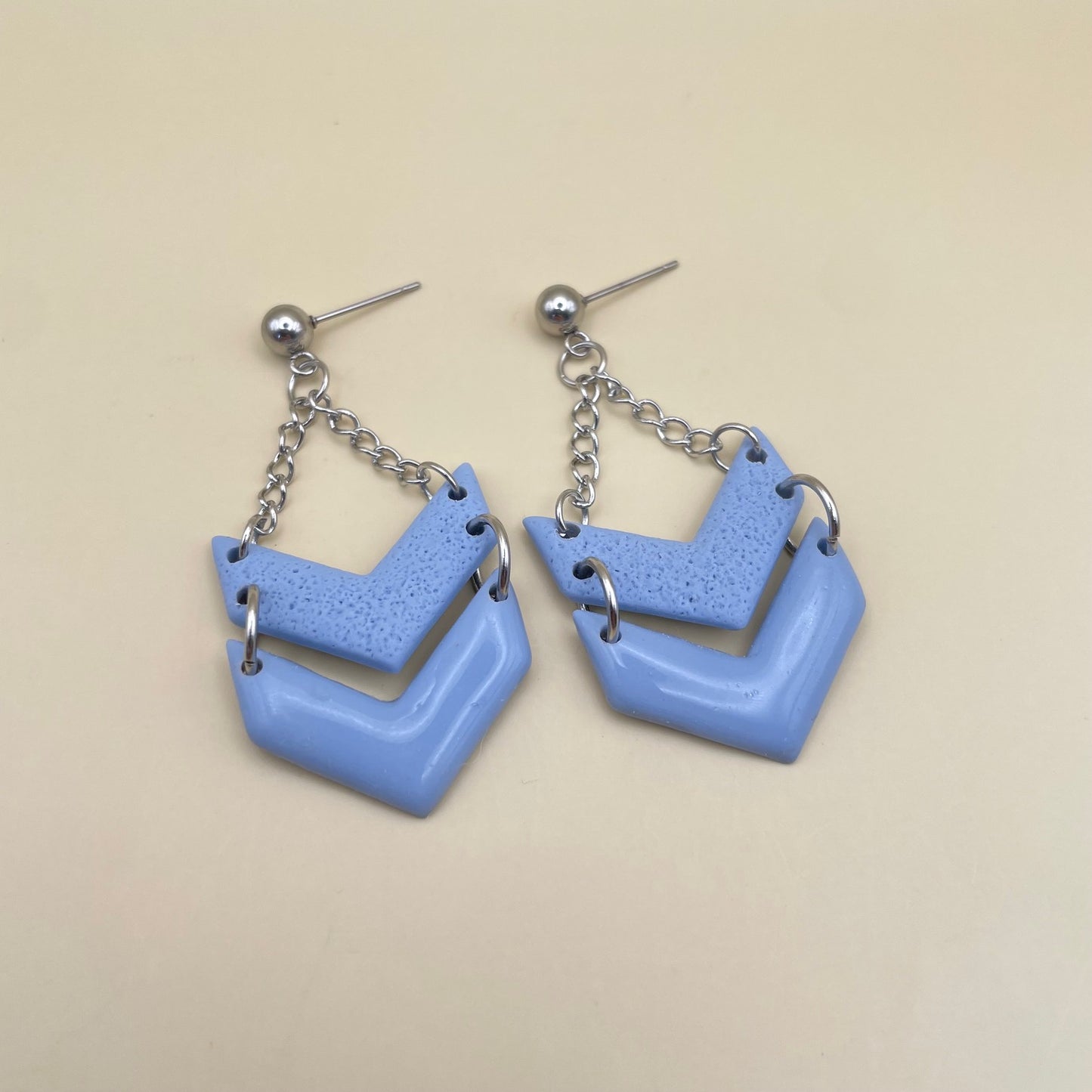 Swinging charms oorbellen licht blauw