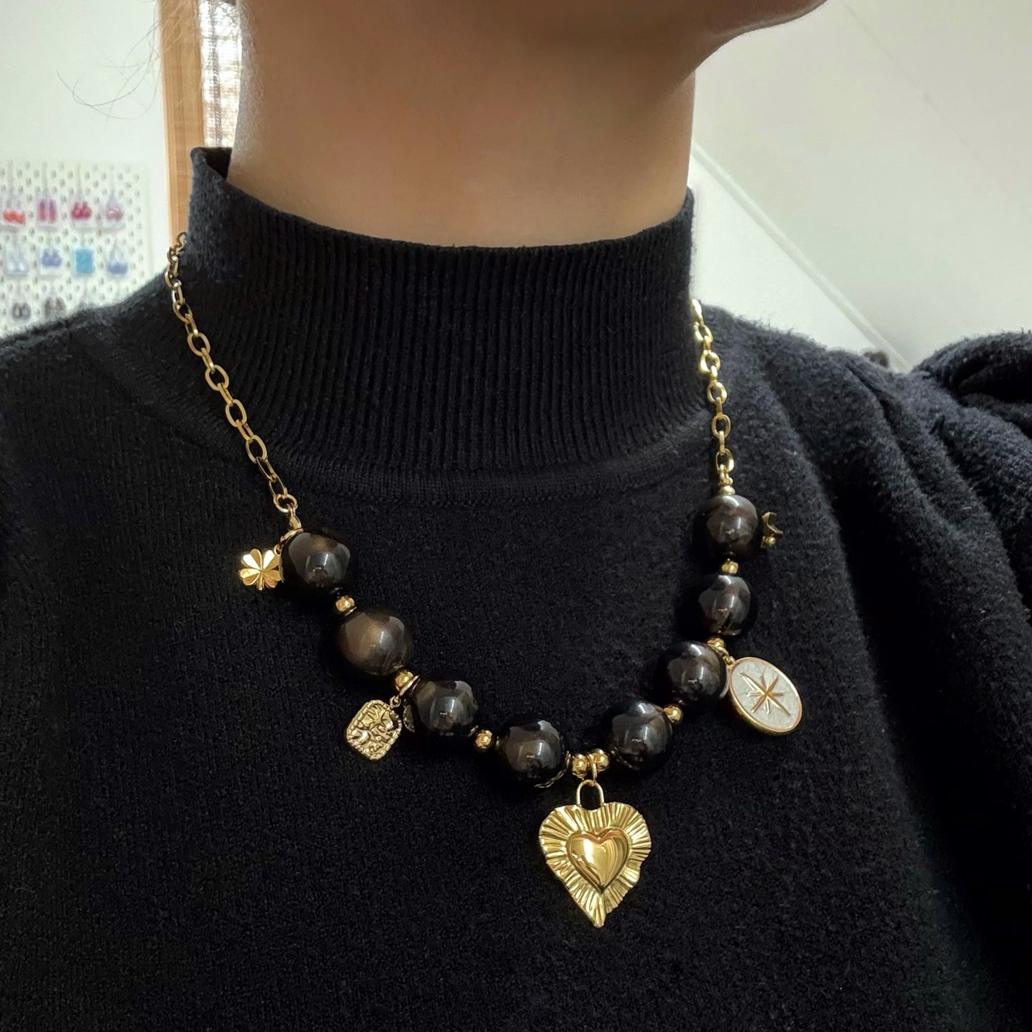 Kralen ketting met hartbedel en gouden charms