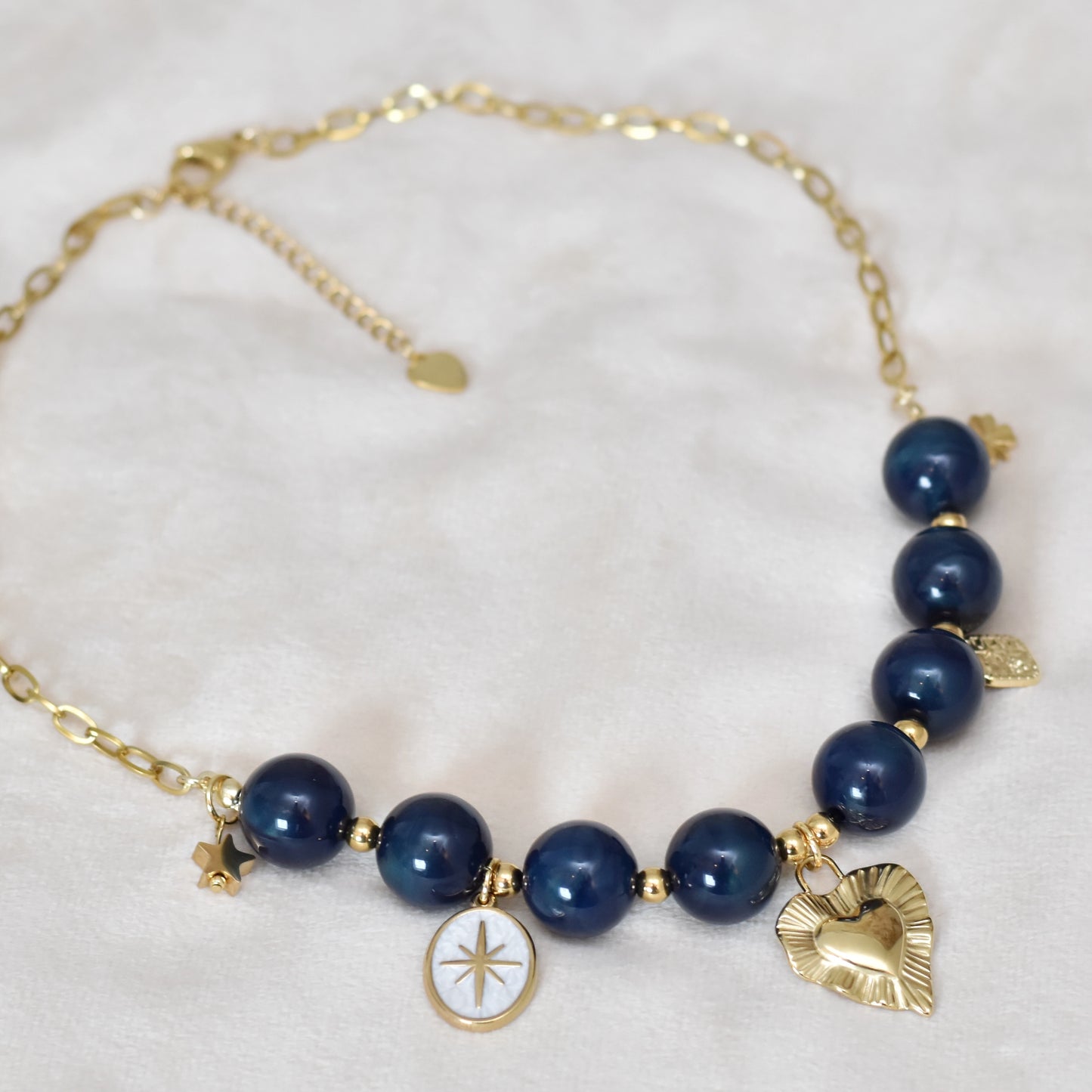 Kralen ketting met hartbedel en gouden charms
