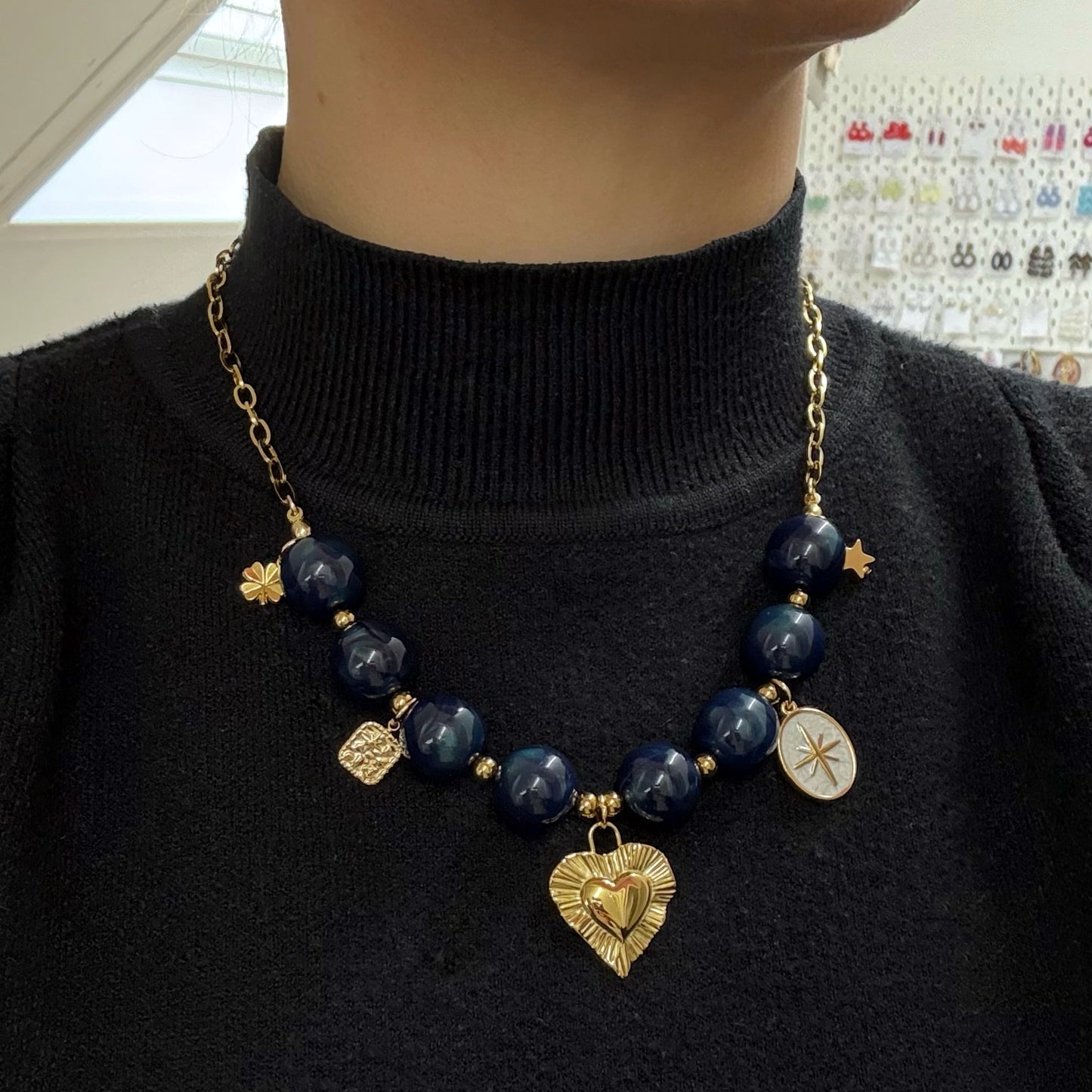 Kralen ketting met hartbedel en gouden charms