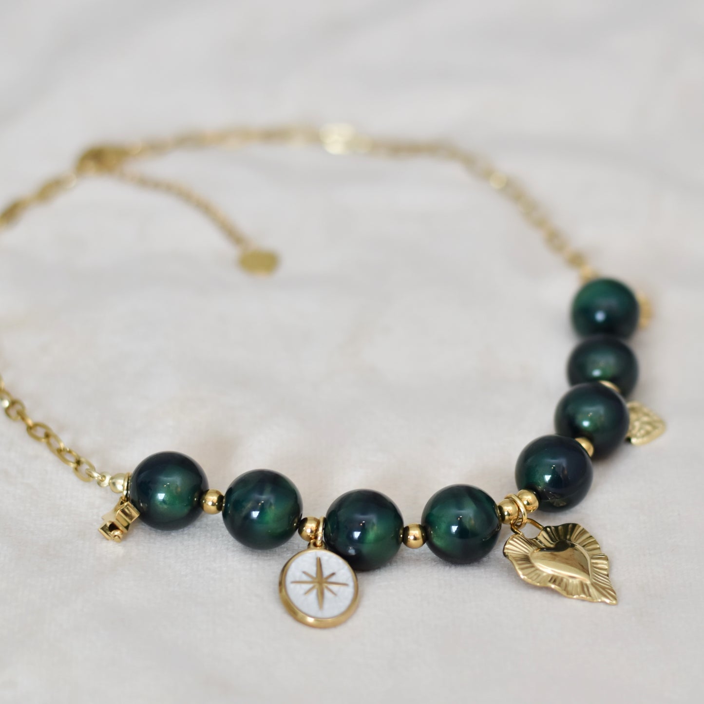 Kralen ketting met hartbedel en gouden charms