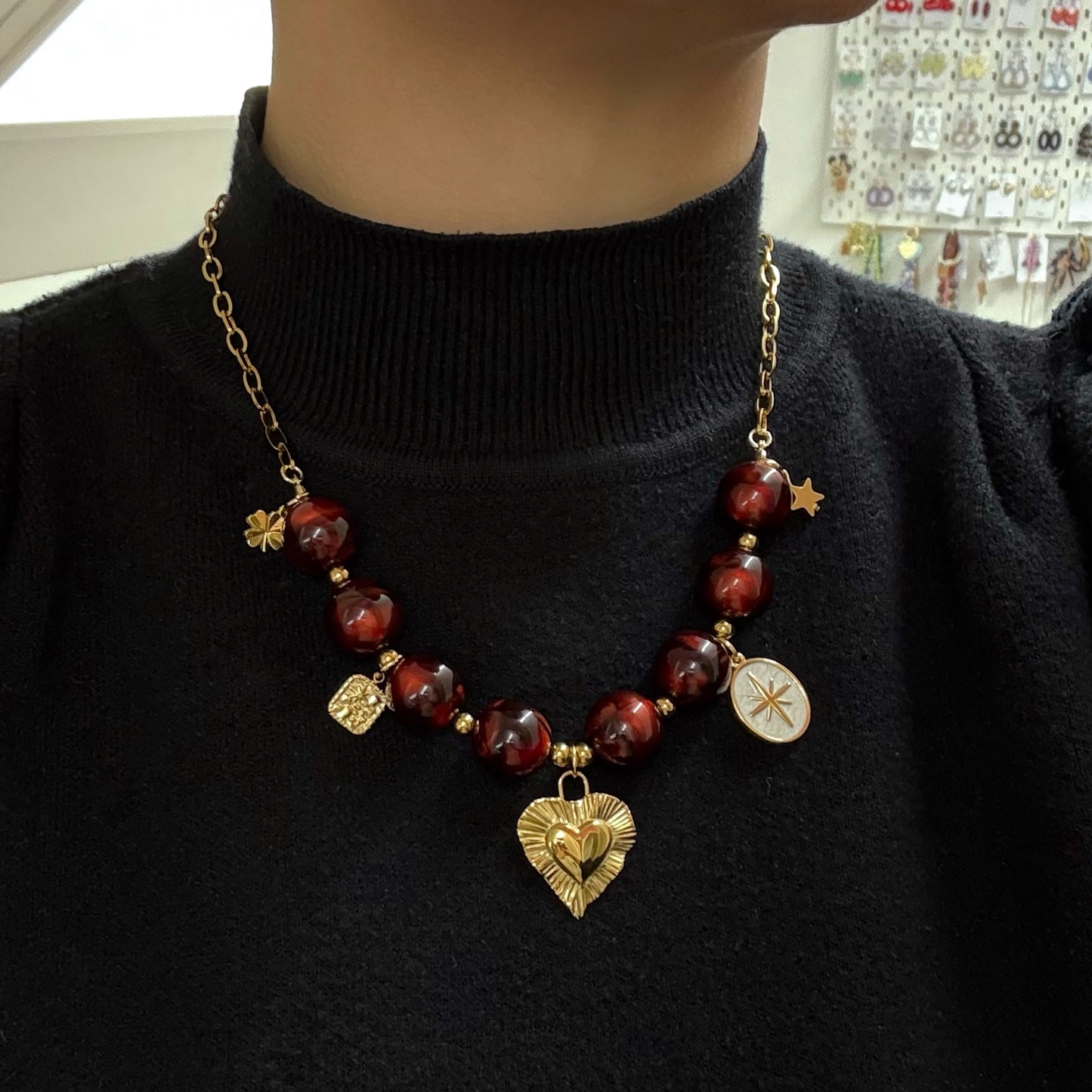 Kralen ketting met hartbedel en gouden charms