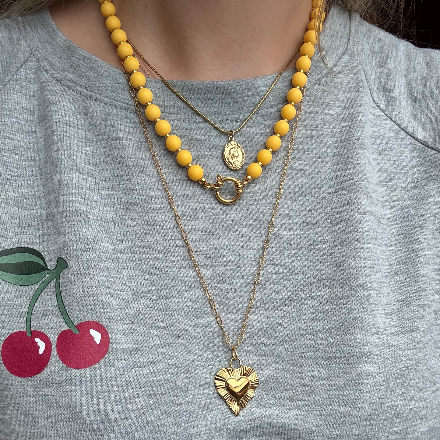 Okergele kralen ketting met gouden accenten en boeislot