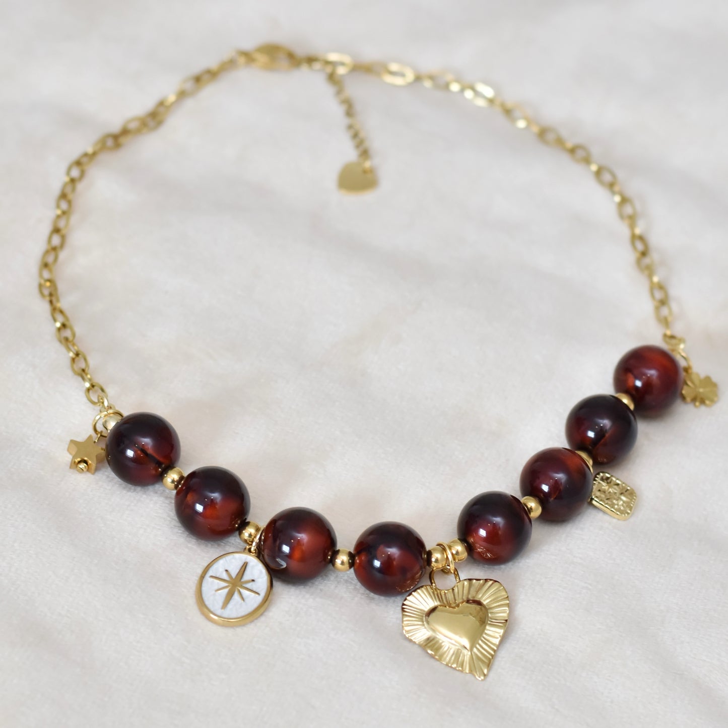 Kralen ketting met hartbedel en gouden charms