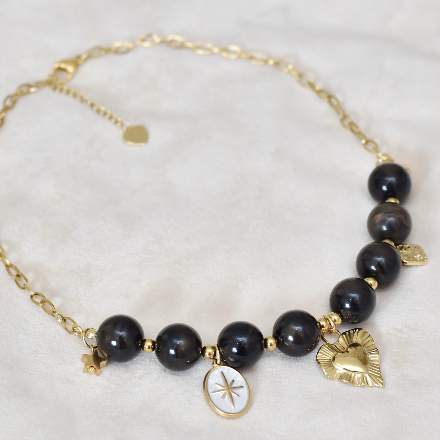 Kralen ketting met hartbedel en gouden charms