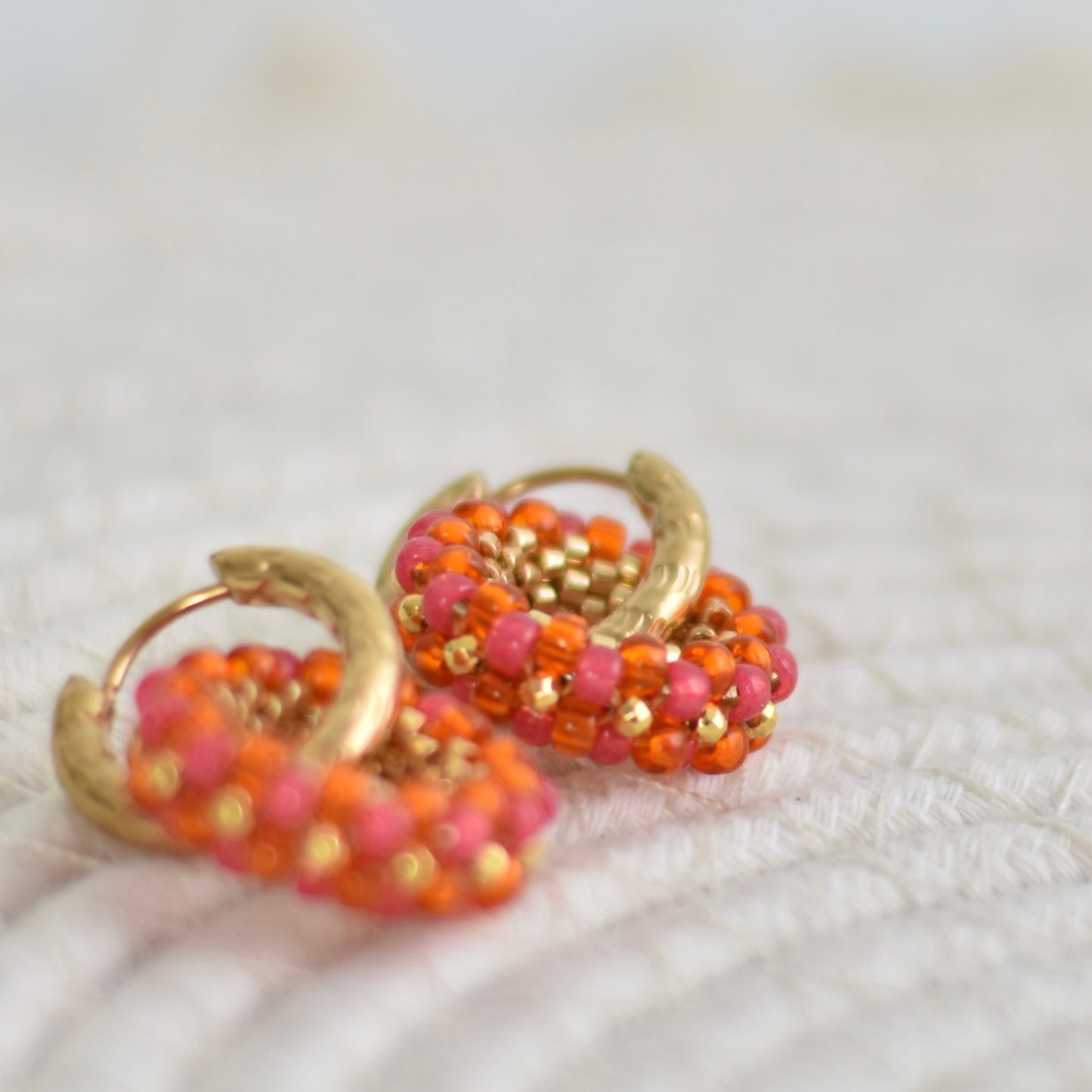 Hoops met kralen bedel - oranje-roze